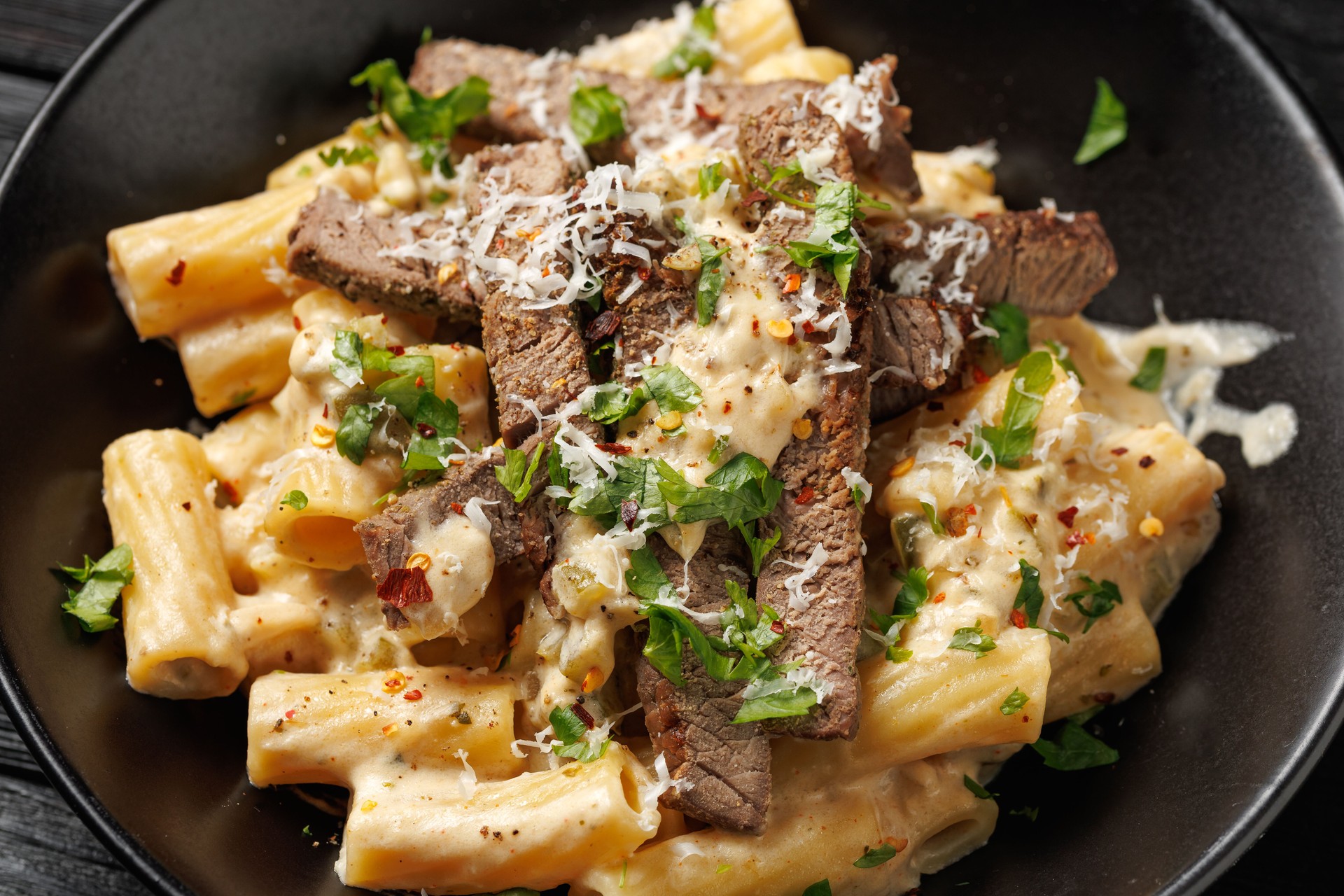Philly cheese steak pasta in black bowl